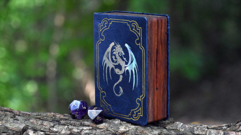 Spellbook Mini Gaming box perched on a branch with amethyst gemstone dice