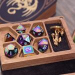 An open Spellbook mini dice box featuring seven spaces for dice, complete with a set of seven metal gaming dice and a golf mini figurine for D&D