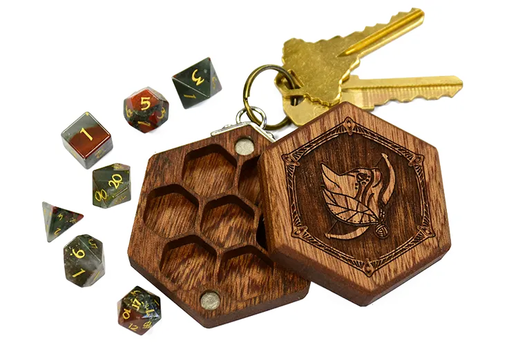 A mahogany wood Mini Hex Chest dice box with a cat ranger engraving and green and red bloodstone mini polyhedral dice for tabletop gaming